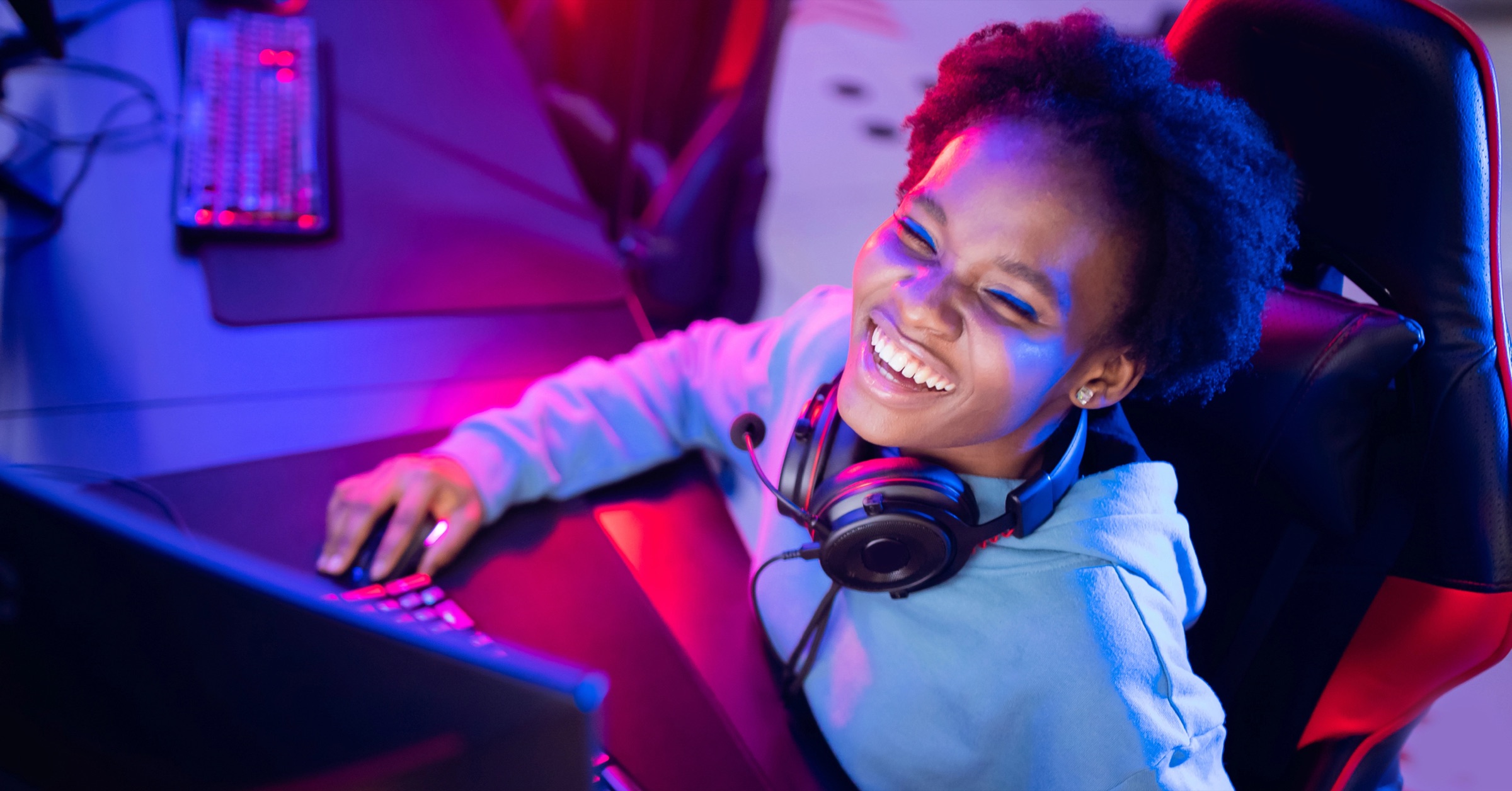 Creator at a neon-lit gaming desk, evenly lit by ShimmerAI