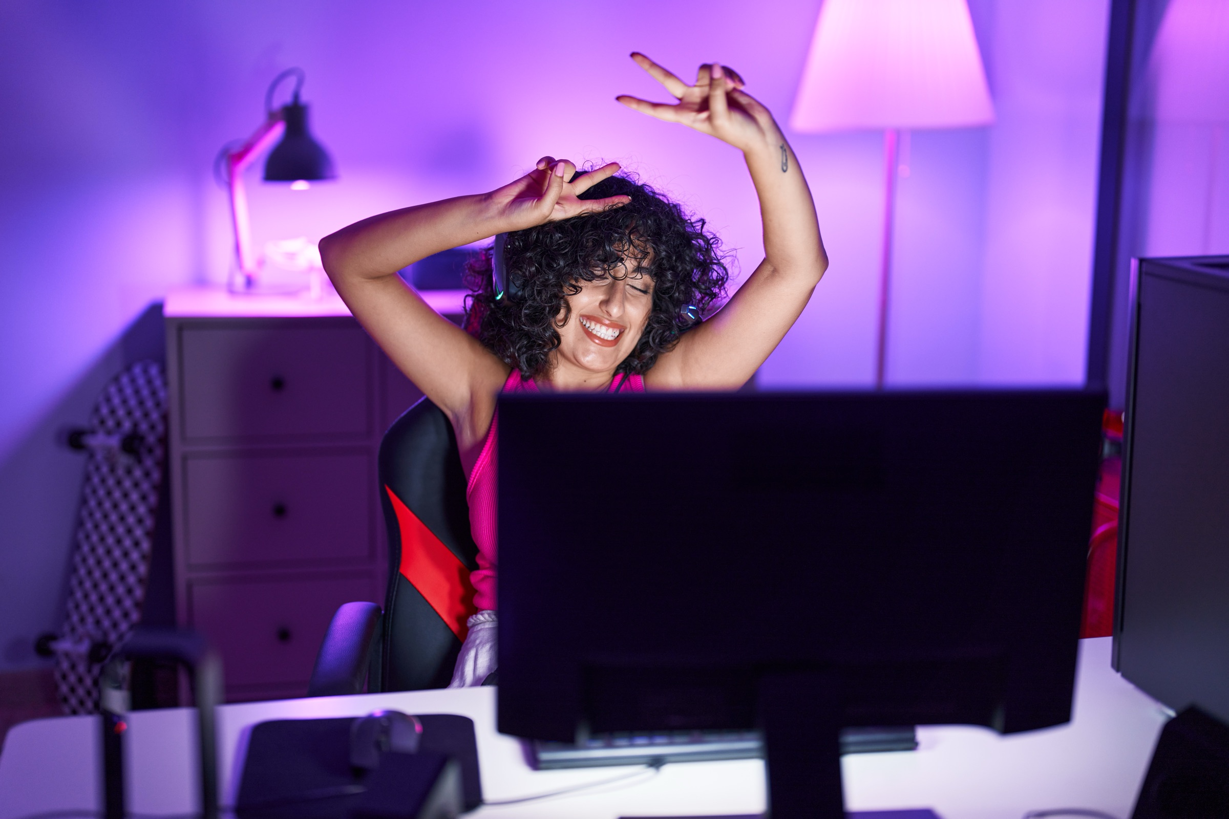 Creator celebrating at a neon-lit gaming desk