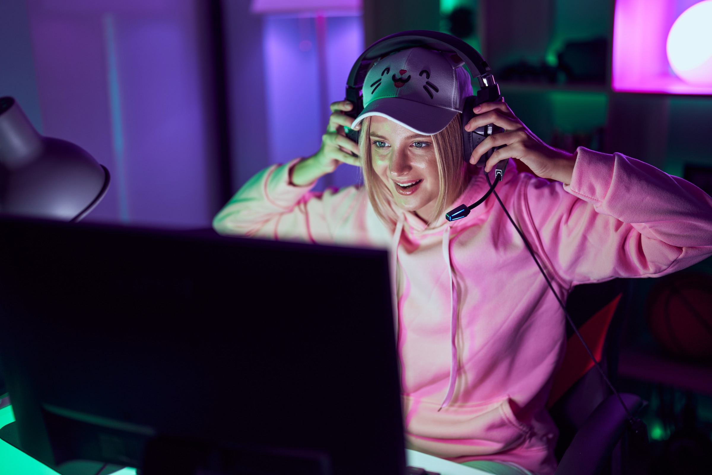 Creator at a neon-lit desk putting on a headset